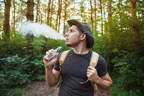 Vaping around the world hipster in a forest travel vape